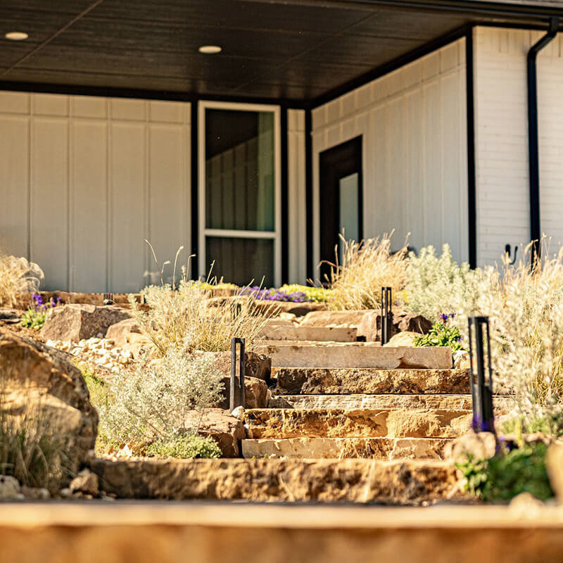 A stone walkway in a backyard